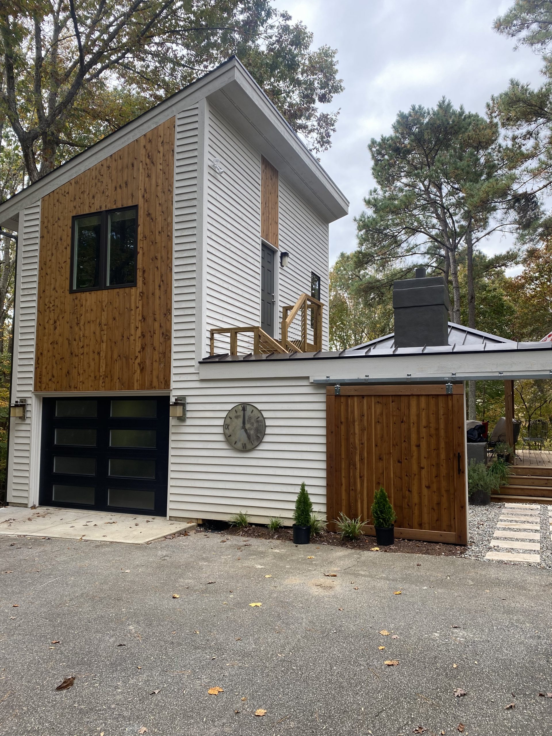 Single car garage with studio apartment above with steps to grade and a privacy wall connecting the main house to the new addition